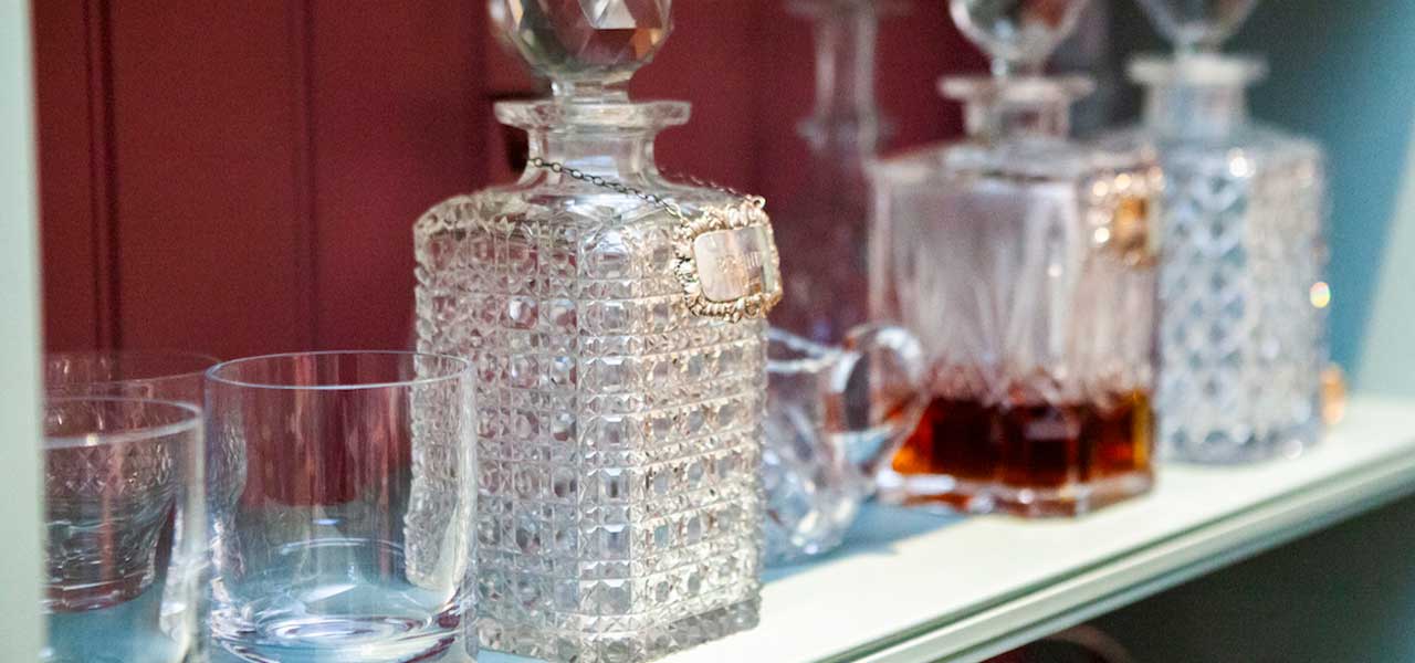 Antique cut crystal decanters and whisky glasses in the Whisky Library at Heritage House, Cotswolds